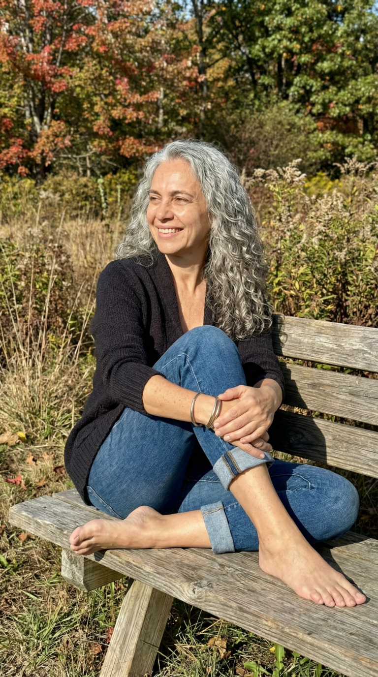 Smiling woman with gray hair relaxing on a bench outdoors